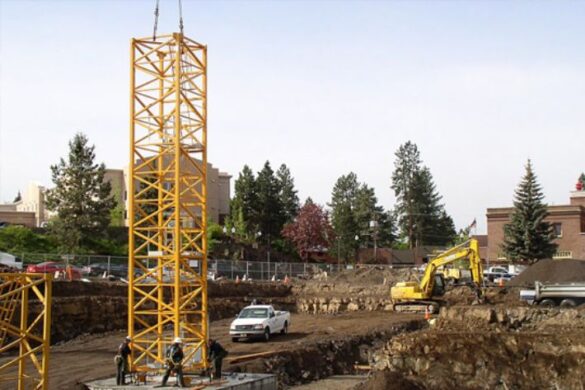 Construction crew working together to rig a load safely while applying SWP checklist procedures and site safety standards
